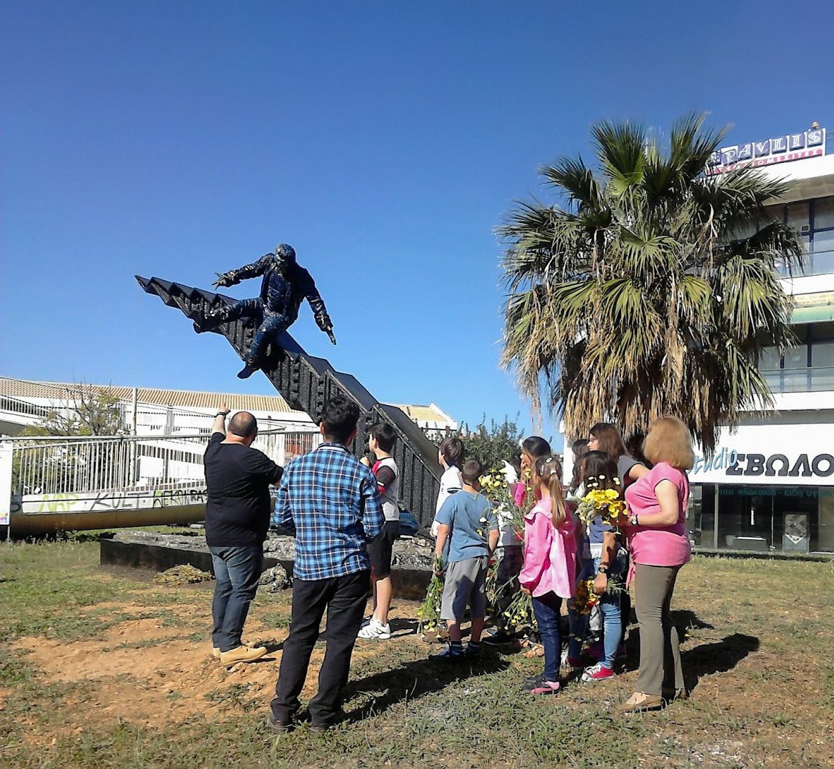 Students pay tribute to the public sculpture Crisis by Anastasios Nyfadopoulos with flowers 